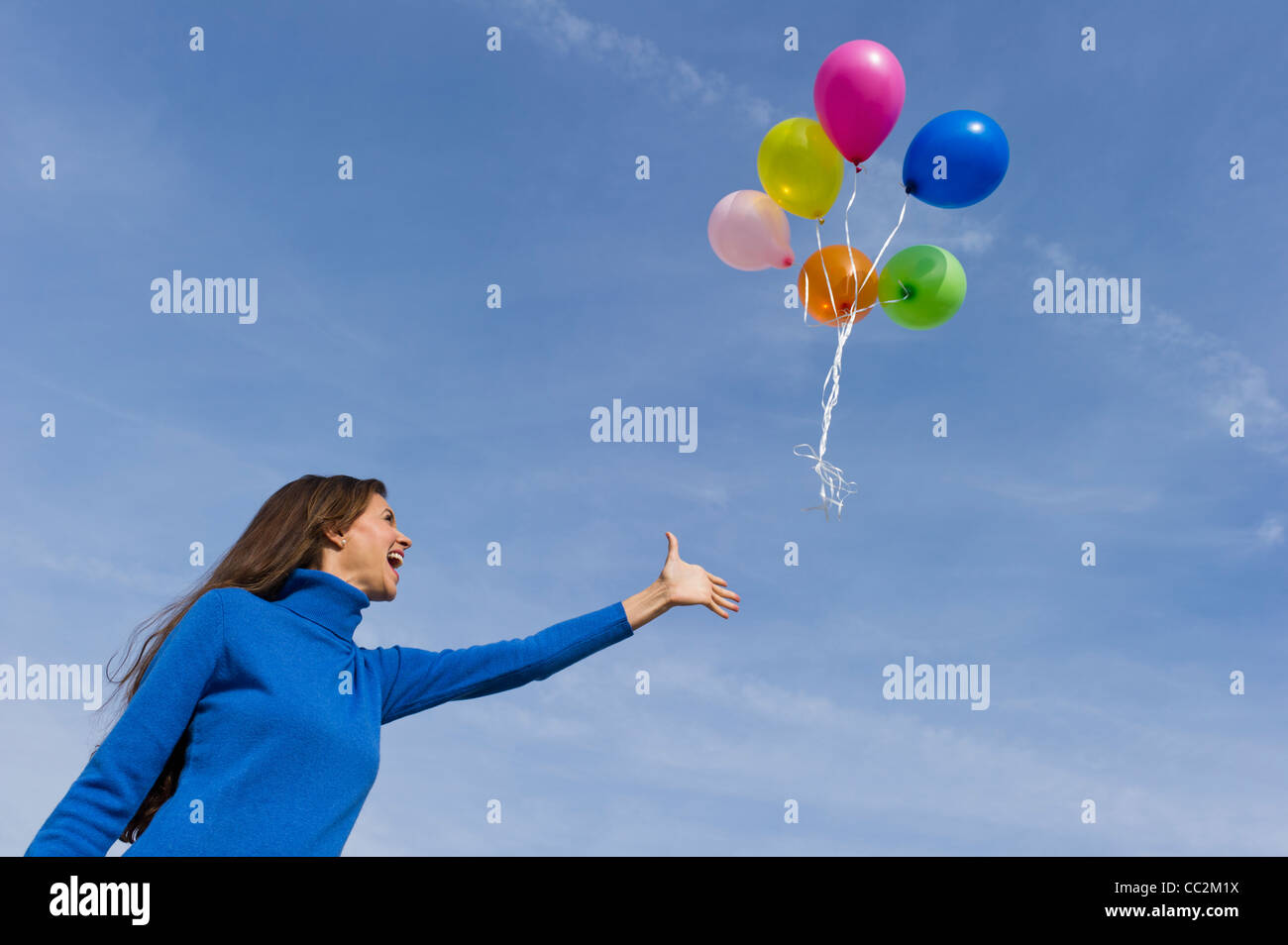 USA, New Jersey, Jersey City, Smiling woman perdre balloons Banque D'Images