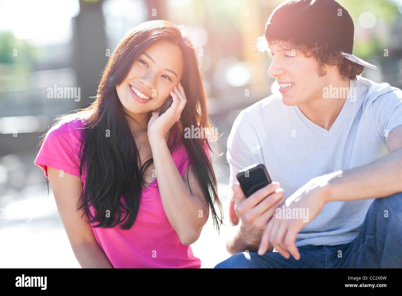 États-unis, Washington, Seattle, jeune multi-raciale couple jouant avec leurs téléphones mobiles Banque D'Images