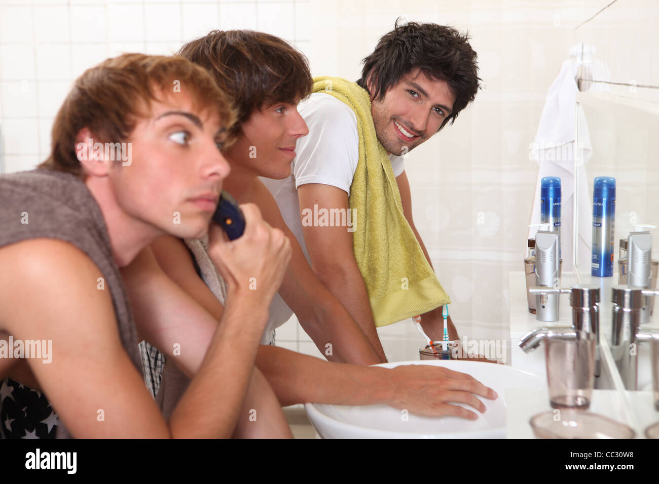 Trois jeunes hommes dans la salle de bains Banque D'Images