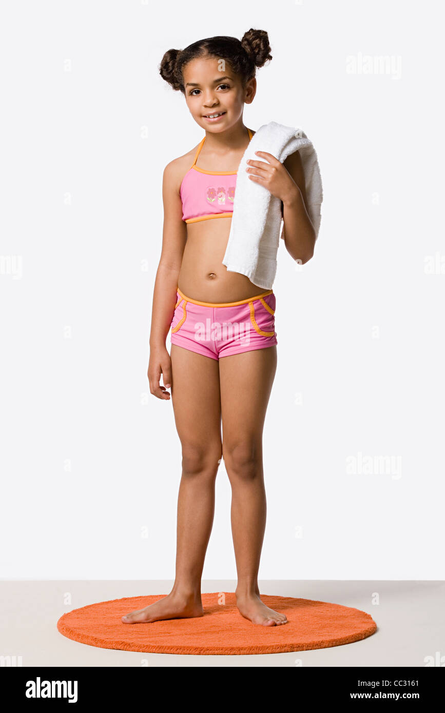 Studio Portrait of Girl (8-9) in bikini holding towel Banque D'Images