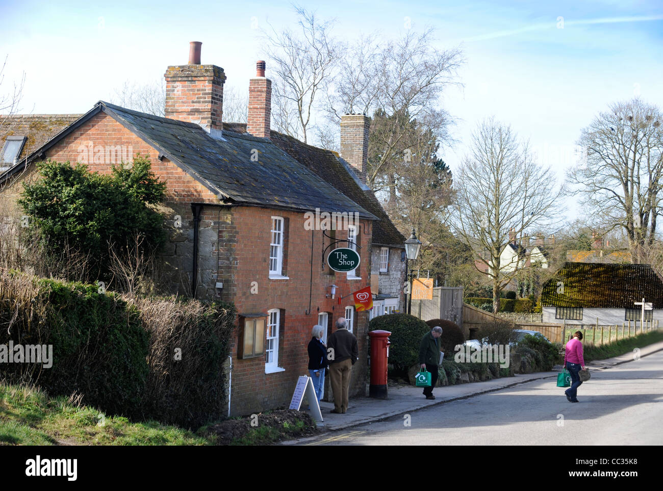 Les clients à l'ouverture d'une communauté courent boutique dans le village d'Avebury Wiltshire, UK Banque D'Images