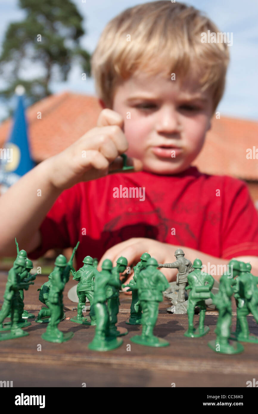 4 ans blonde boy playing toy soldiers Banque D'Images