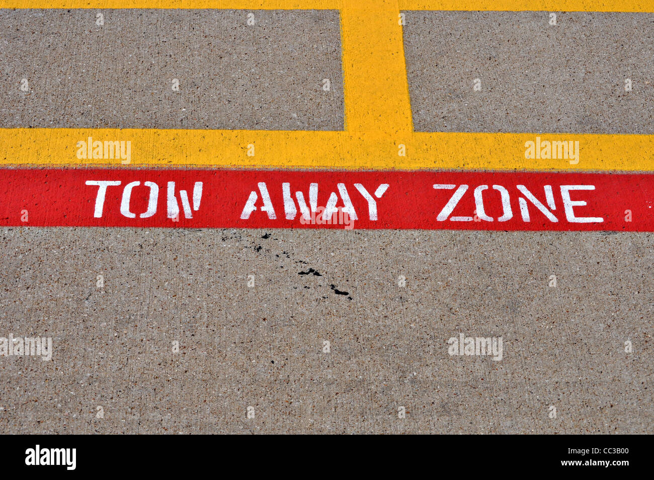 Une zone-remorquage peint signe est peint sur le ciment de stationnement. Banque D'Images Une zone-remorquage peint signe est peint sur le ciment de stationnement. Banque D'Images