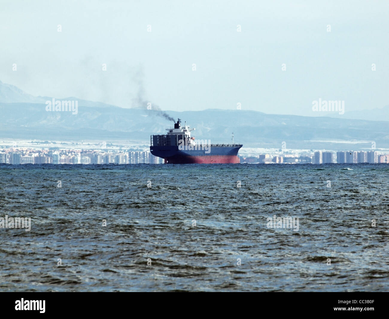 Un grand navire de fret à travers le cours d'eaux de la mer Méditerranée, au large de la station balnéaire espagnole de Roquetas-De-Mar Banque D'Images