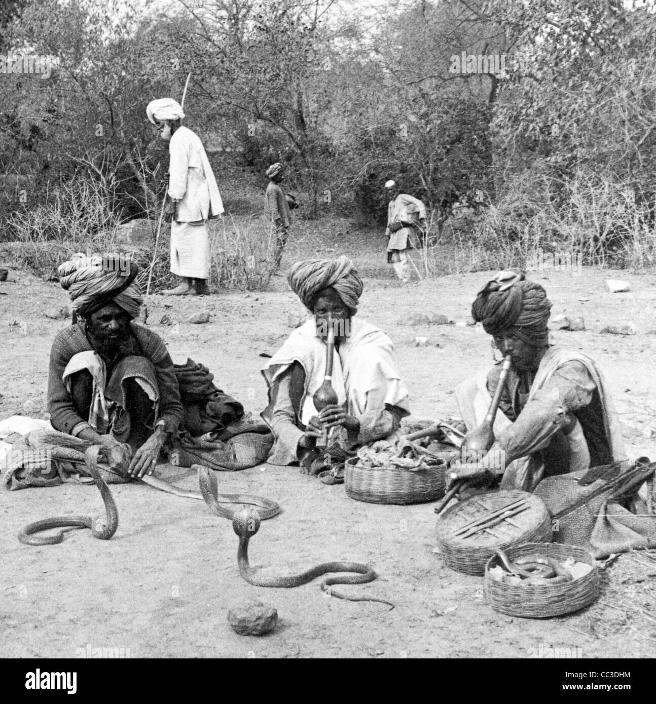 Charmeurs de manipulation de la deadly hooded cobra - Delhi, Inde, circa 1900 Banque D'Images