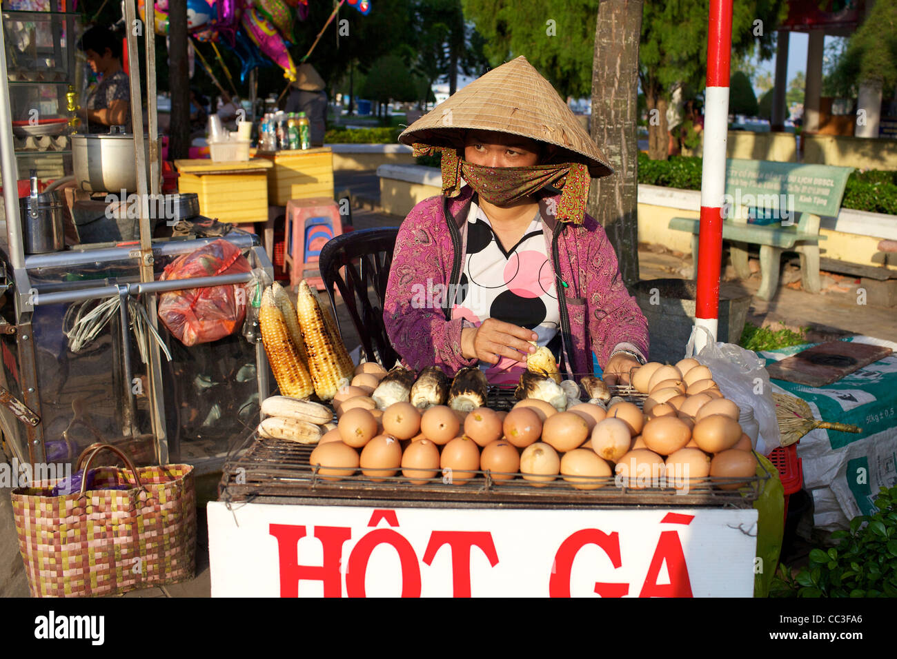 Vendeur de rue vietnamiens maïs grillé et d'œufs de vente sur rue à Can Tho, Vietnam Banque D'Images