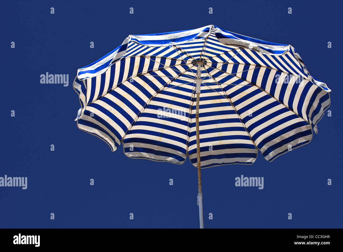 Vieux parasol contre un ciel bleu profond arrière-plan. Banque D'Images