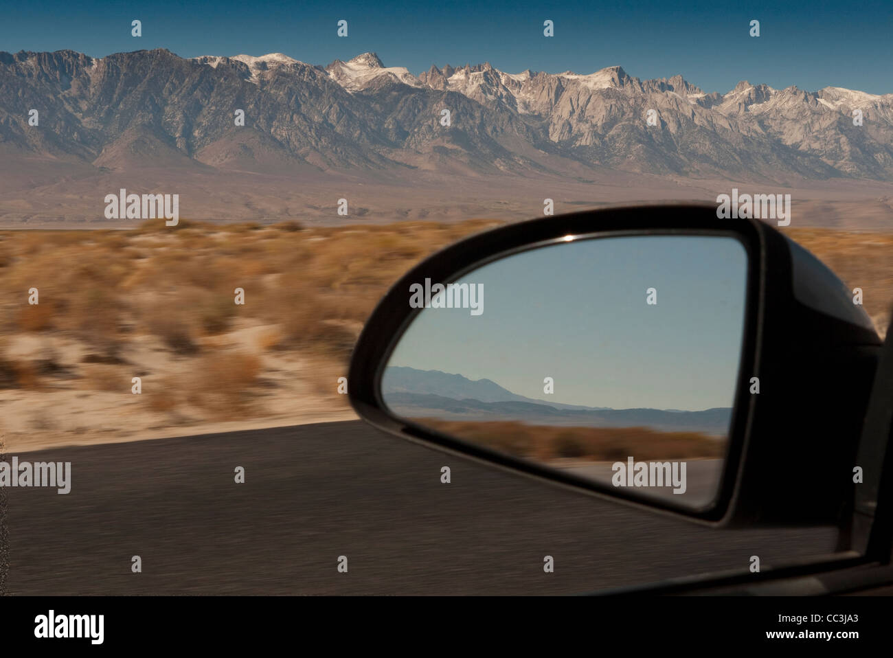 La réflexion en miroir de voiture la conduite à travers le désert près de Lone Pine en Californie. Banque D'Images
