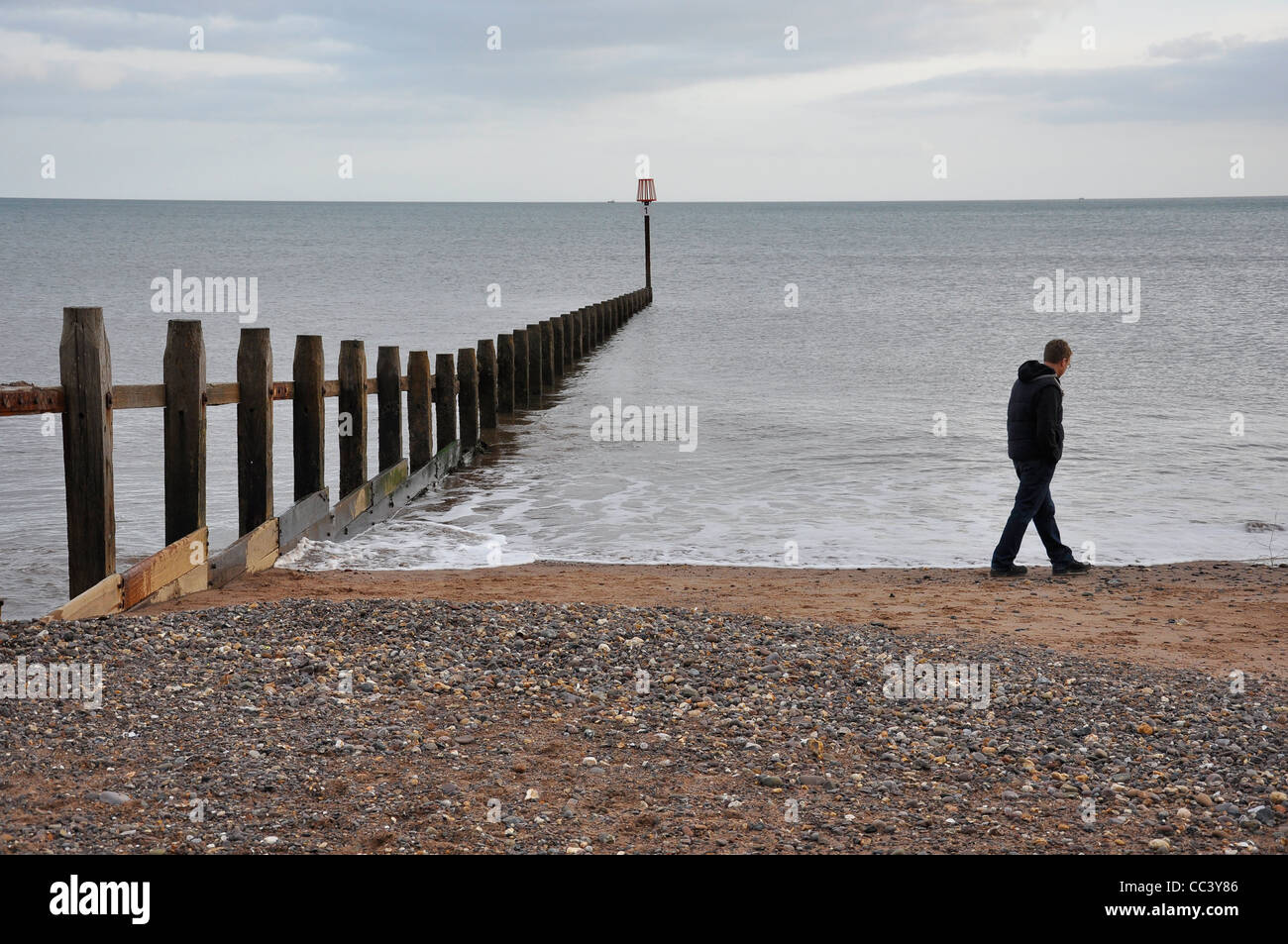 L'homme seul sur la plage d'hiver. Banque D'Images
