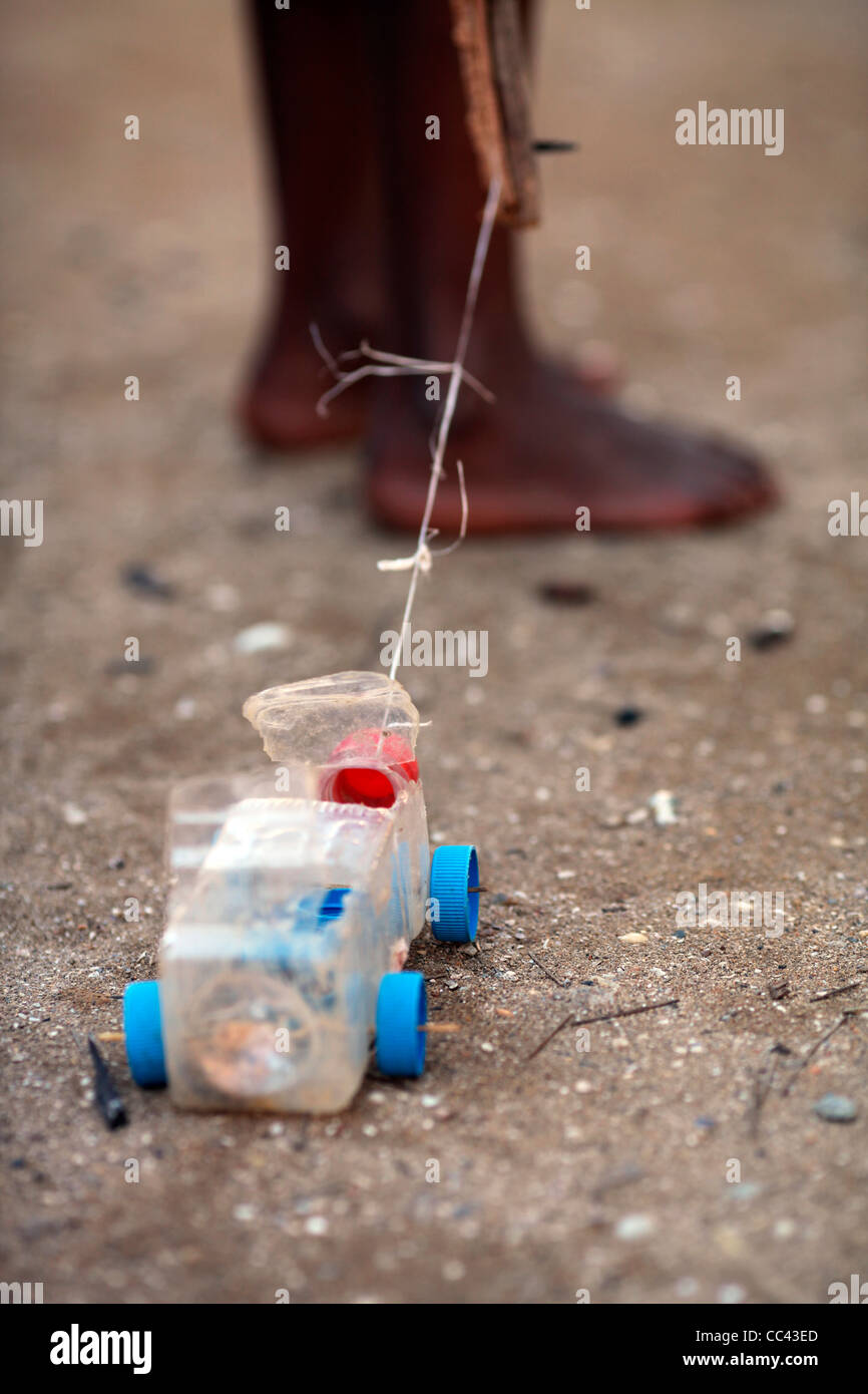 Détail d'un jouet voiture camion camade recyclé d'une bouteille en plastique et plusieurs caps tiré par un garçon à l'aide d'une chaîne de Nosy Komba Banque D'Images