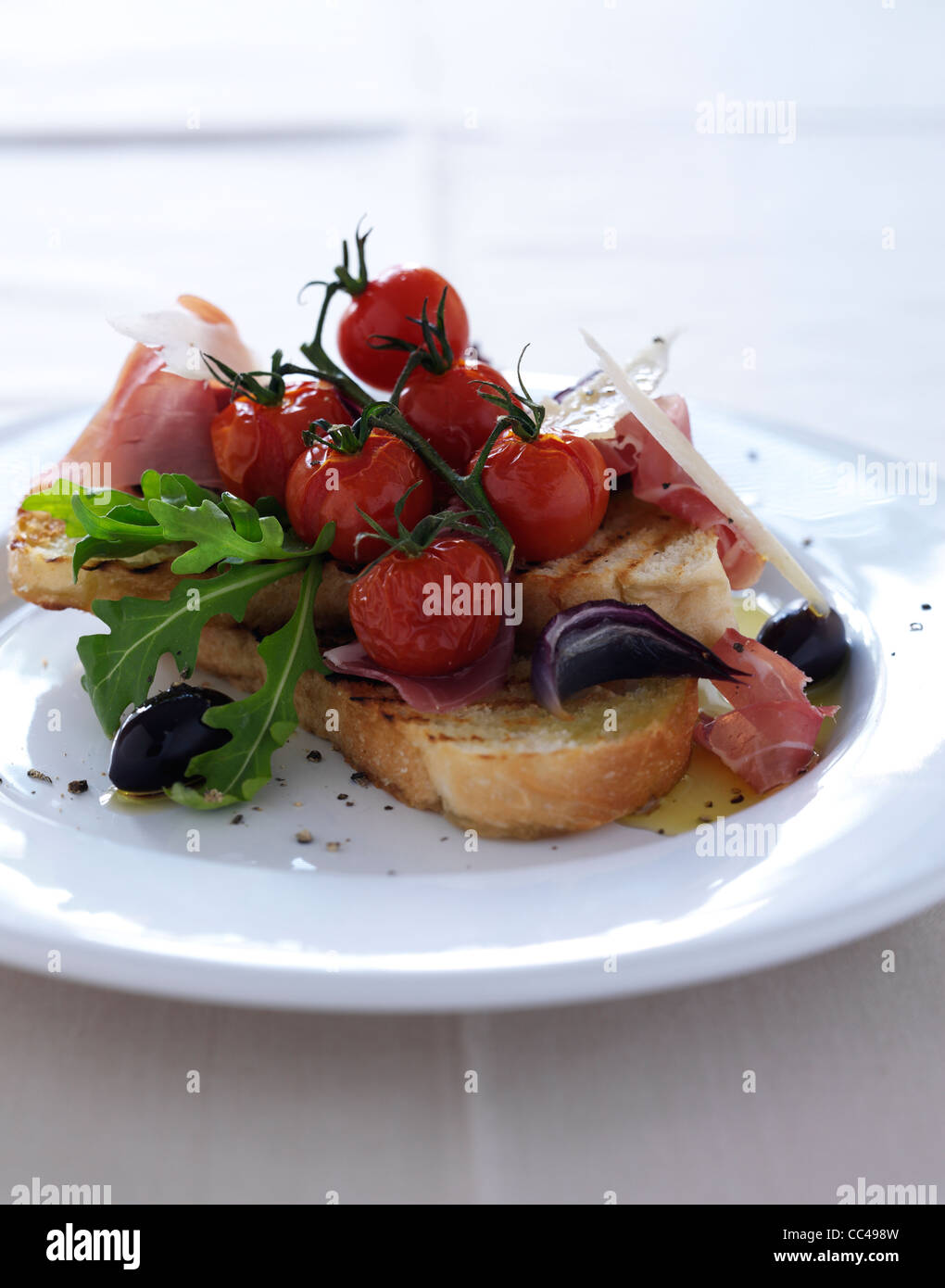 Bruschettas aux légumes rôtis jambon de Parme et de copeaux de parmesan Banque D'Images