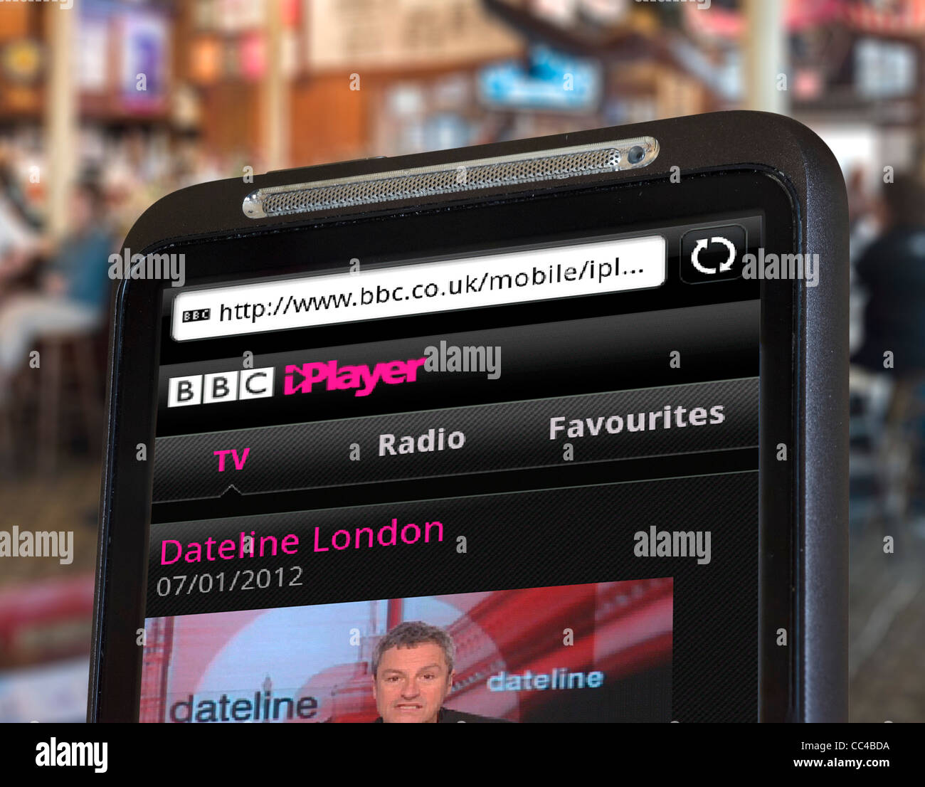 Regarder la Chaîne infos sur BBC iPlayer sur un smartphone HTC via une connexion Wi-Fi publique Banque D'Images