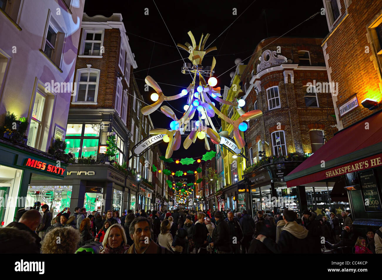 Carnaby Street plein d'acheteurs de Noël, Londres, Angleterre, Royaume-Uni, avec décoration de fête des lumières dans la nuit Banque D'Images