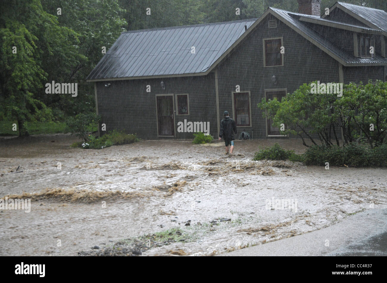 Une inondation victime fait son chemin vers sa maison après la crue des eaux de la tempête tropicale Irène. lui a causé d'évacuer à Fayston, VT Banque D'Images