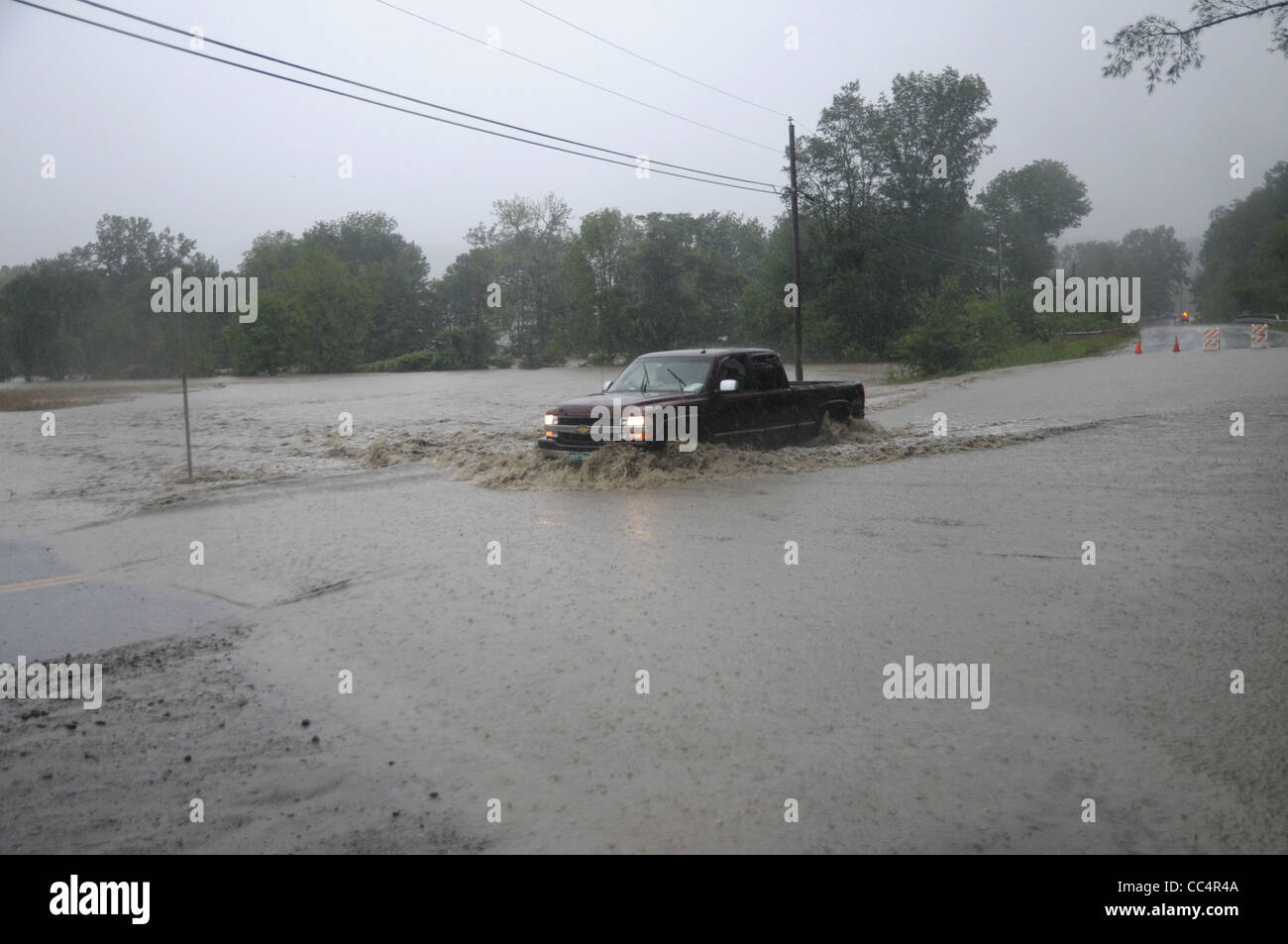 Un pilote dans un camion tente de pousser à travers les eaux d'inondation causée par la tempête tropicale Irène dans Waitsfield, Vermont. Banque D'Images