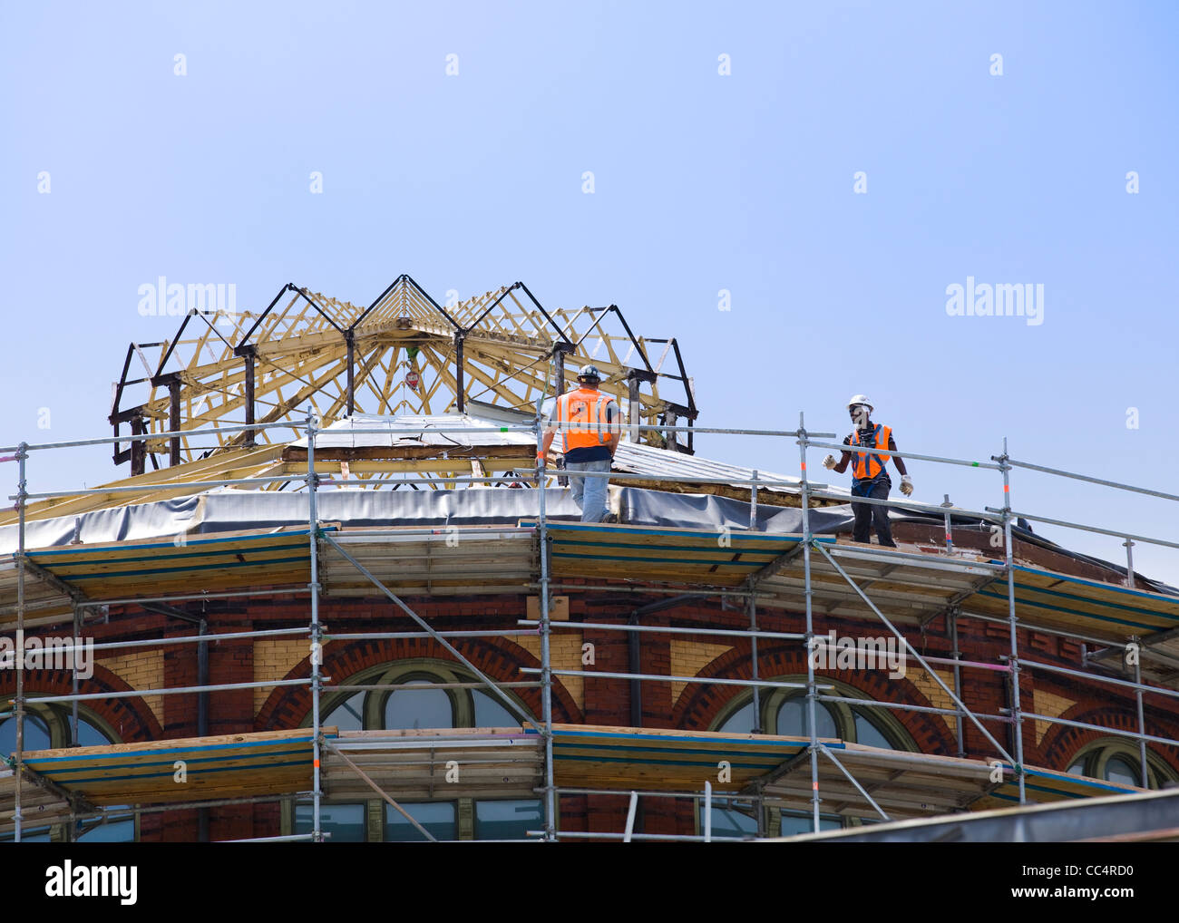 Les travailleurs de la construction sur un échafaudage sur le toit Banque D'Images