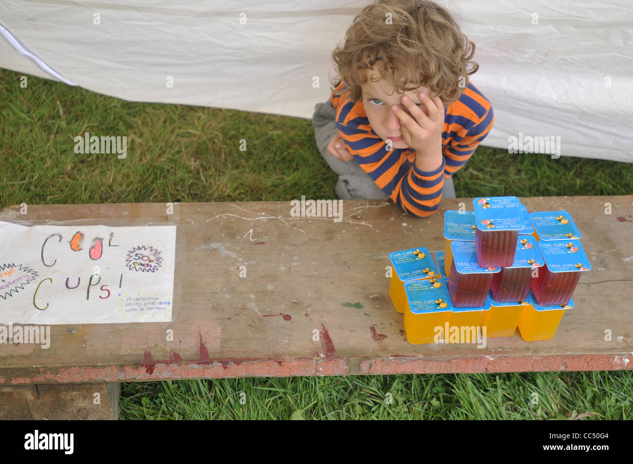 Un garçon de six ans de fatigue après le "vendre" des boissons lors d'une fête Banque D'Images