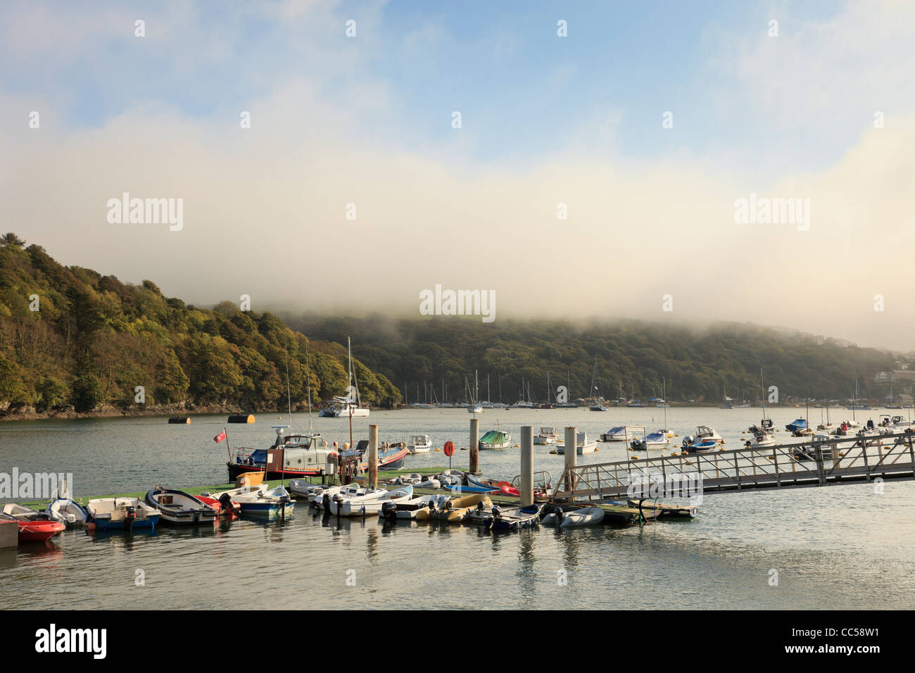 Fowey, Cornwall, Angleterre, Royaume-Uni, Grande Bretagne. Bateaux amarrés sur la rivière Fowey avec sea mist clearing sur les collines Banque D'Images