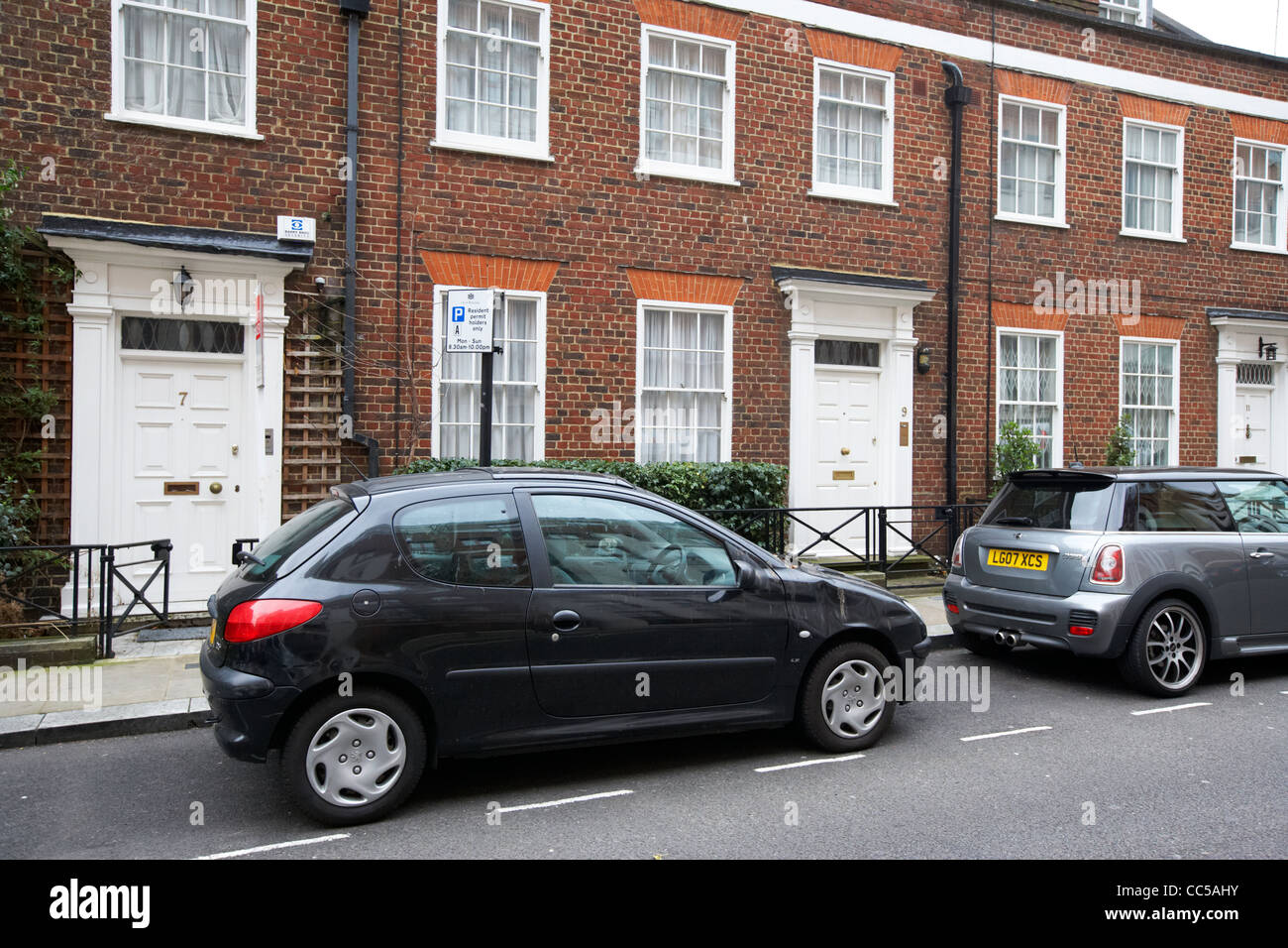 Voitures garées dans les places de parking en face de townhouses lancelot place knightsbridge London England uk united kingdom Banque D'Images