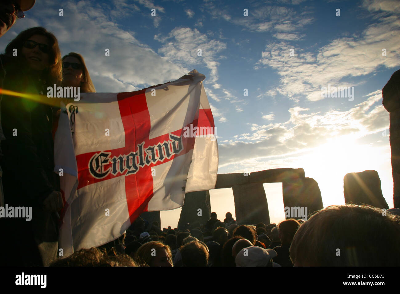 La croix de Saint Georges est agité au lever du soleil au solstice d'été festival à Stonehenge en Witshire Banque D'Images