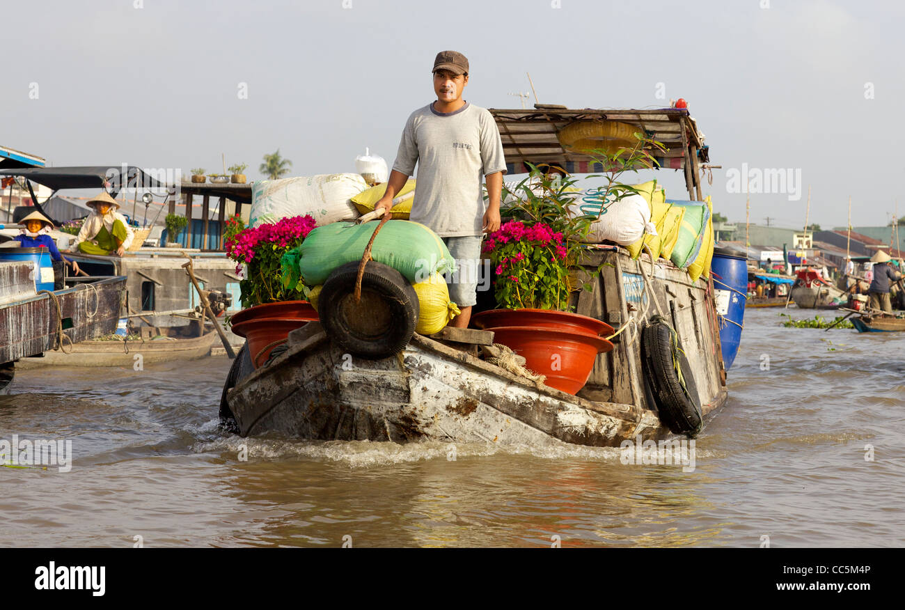 Vente de fleurs vietnamiennes non identifiés à partir de leur bateau dans le célèbre marché flottant de Can Tho à Can Tho, Vietnam Banque D'Images