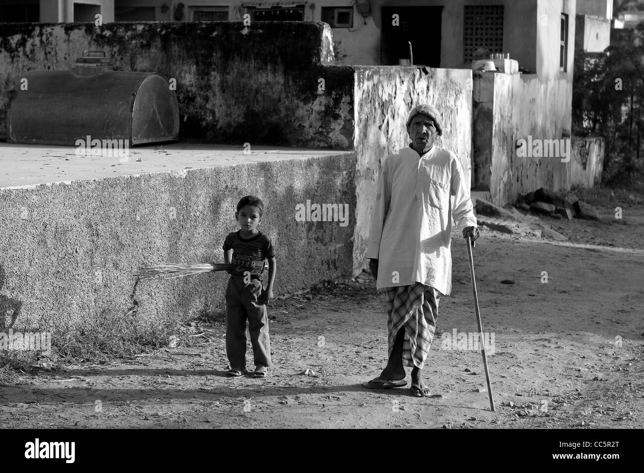 Old man and boy walking in Indian village. Banque D'Images