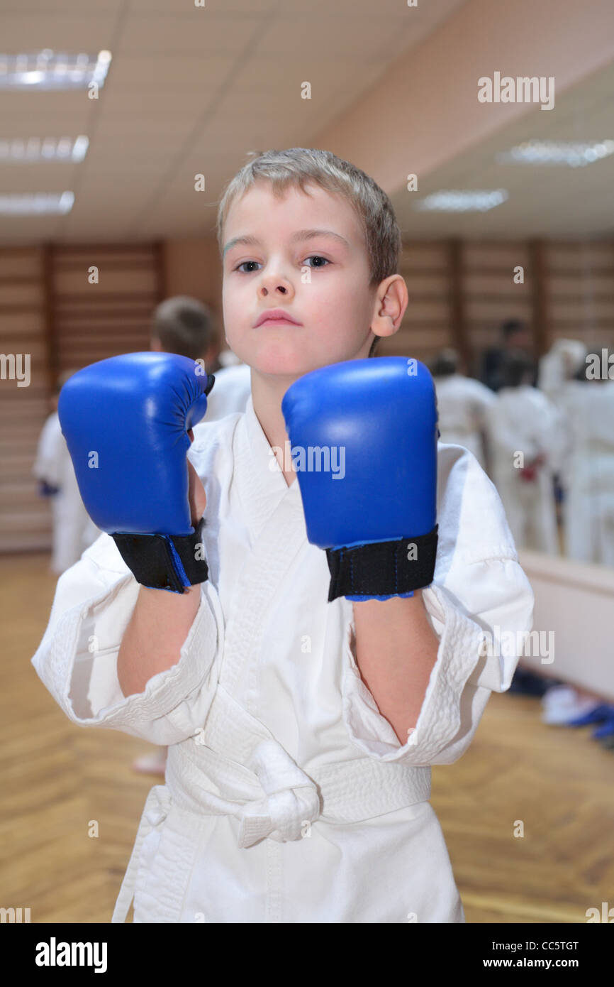 Boy in sports hall in boxing gloves Banque D'Images