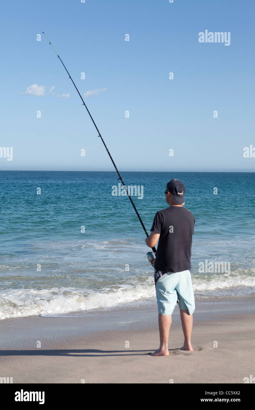 Un homme plage casting, la pêche sur la plage à Red Bluff, Kalbarri, Australie occidentale Banque D'Images