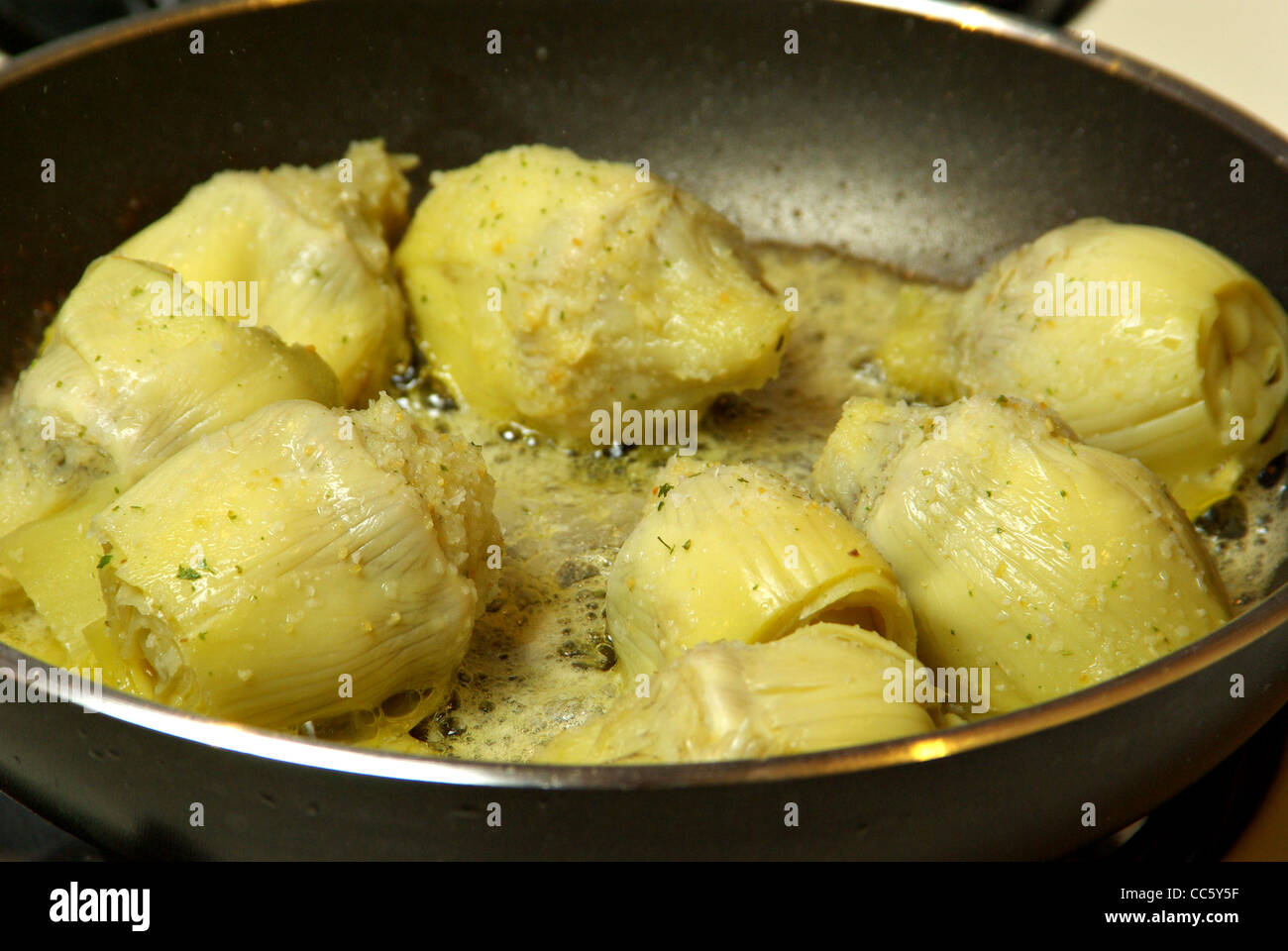 Les coeurs d'artichauts sont cuits sur une cuisinière. Banque D'Images