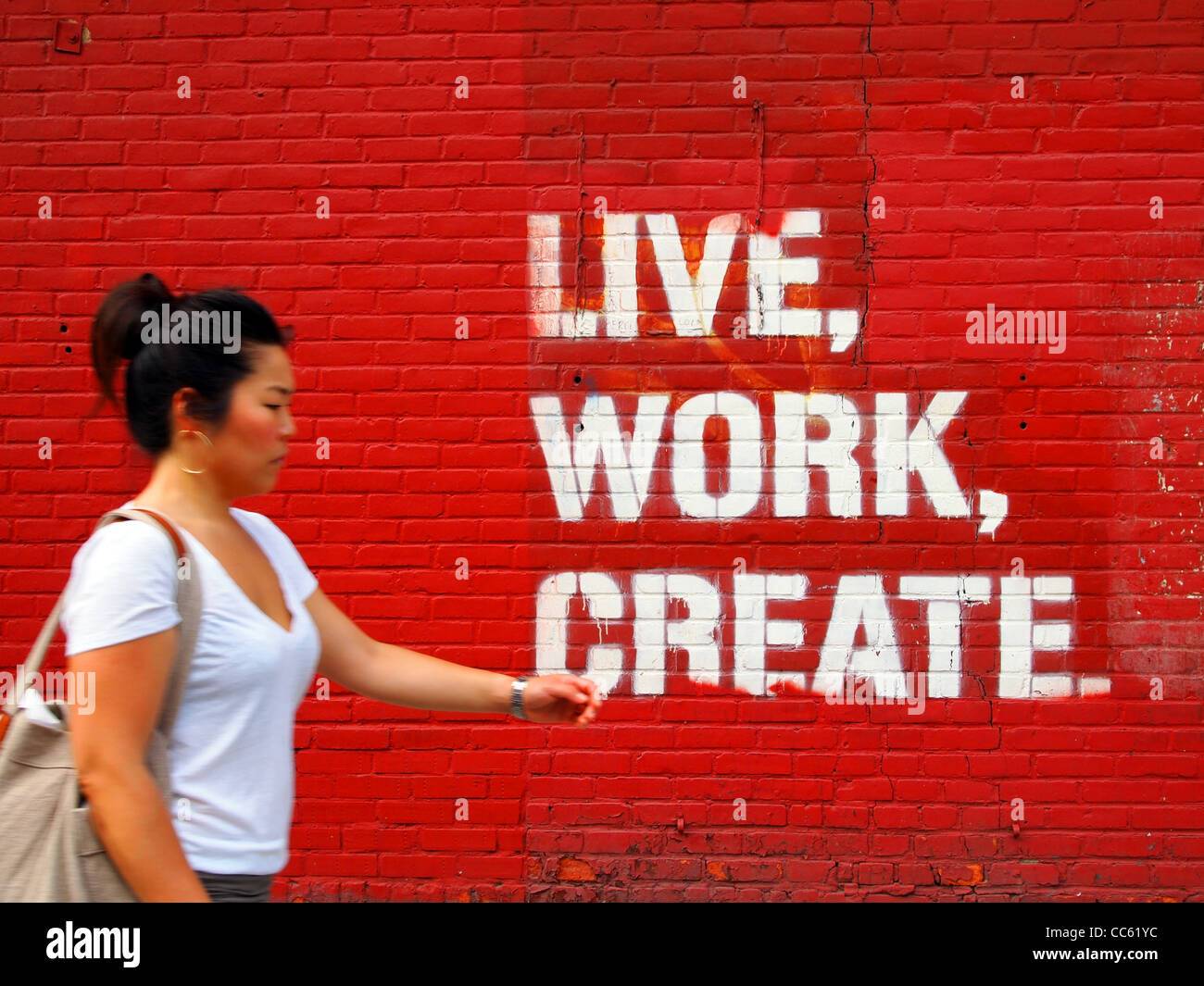 Les mots Vivre, travailler, créer peint à la bombe sur le mur de brique rouge à Manhattan, New York City. Banque D'Images