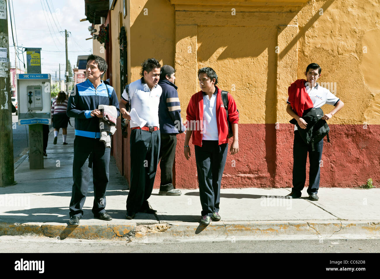 Groupe d'adolescents de bonne humeur Mexican garçons debout sur coin de rue après l'école en face de colorful wall Oaxaca Banque D'Images