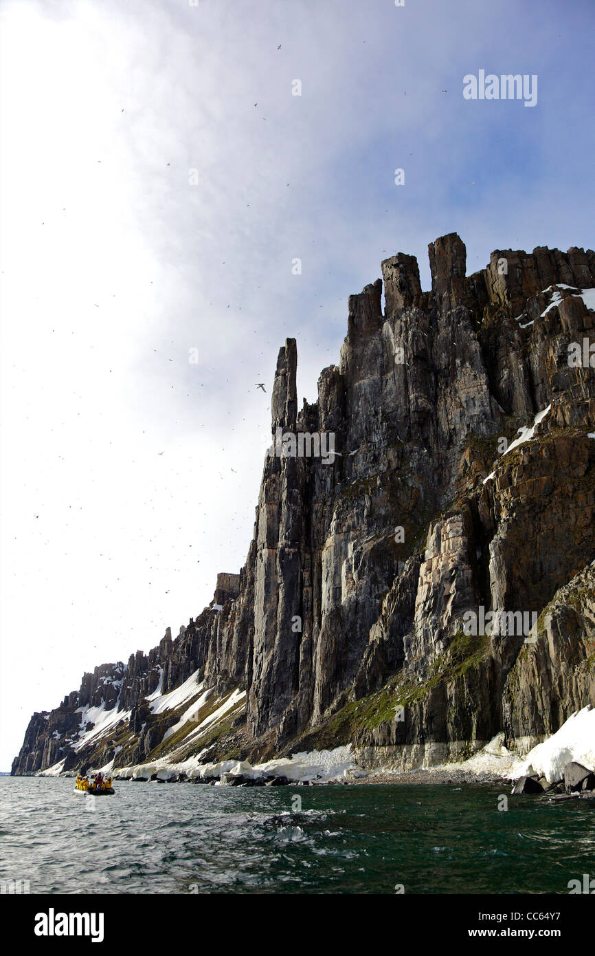 Les touristes en croisière en zodiac aventure arctique jeux gonflables, des falaises Alkefjellet colonie d'oiseaux de mer en été, Spitzberg, Svalbard Banque D'Images Les touristes en croisière en zodiac aventure arctique jeux gonflables, des falaises Alkefjellet colonie d'oiseaux de mer en été, Spitzberg, Svalbard Banque D'Images