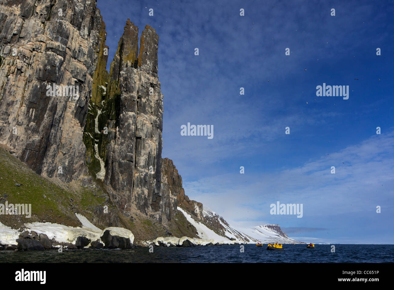 Les touristes en croisière en zodiac aventure arctique jeux gonflables, des falaises Alkefjellet colonie d'oiseaux de mer en été au Spitzberg, Svalbard Banque D'Images Les touristes en croisière en zodiac aventure arctique jeux gonflables, des falaises Alkefjellet colonie d'oiseaux de mer en été au Spitzberg, Svalbard Banque D'Images
