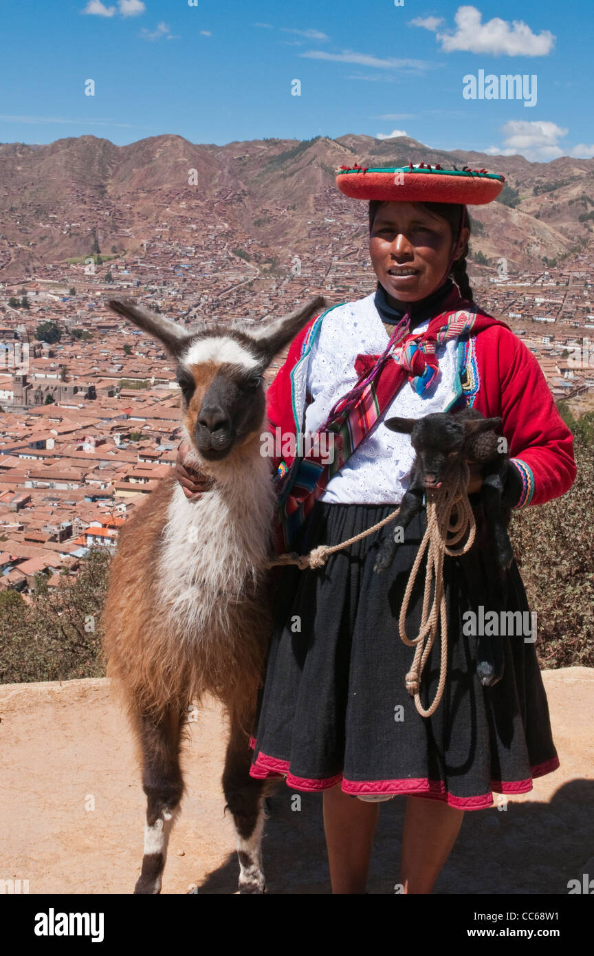 Femme péruvienne et sa lama pose pour les photos, Cusco, Pérou. Banque D'Images