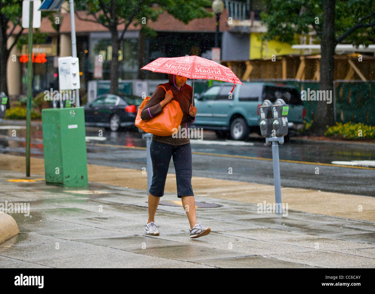 Une femme marchant seule sur un jour de pluie tenant un parapluie - USA Banque D'Images