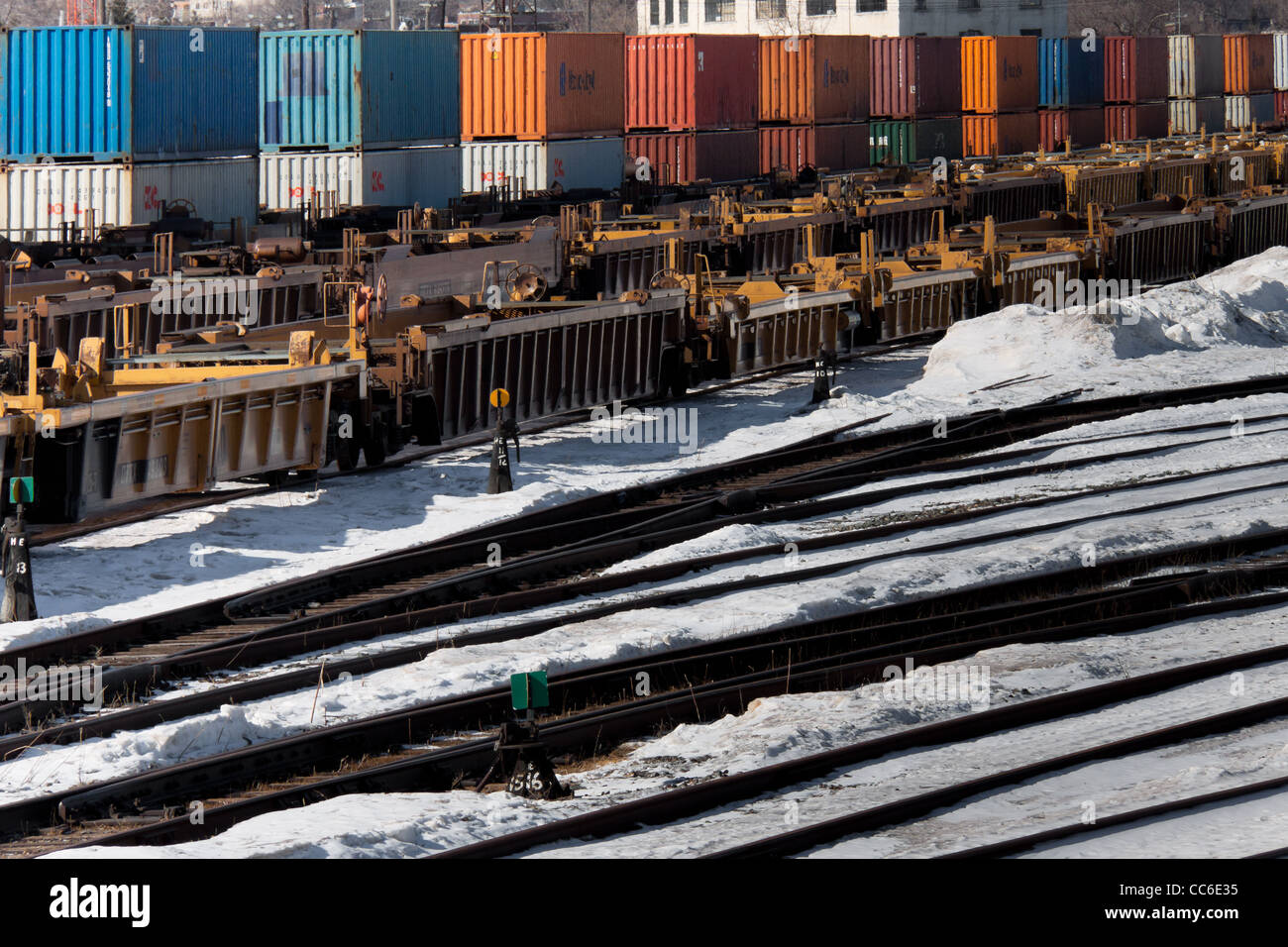 Terminal ferroviaire industriel en hiver avec les wagons porte-conteneurs, des rails et des commutateurs Banque D'Images