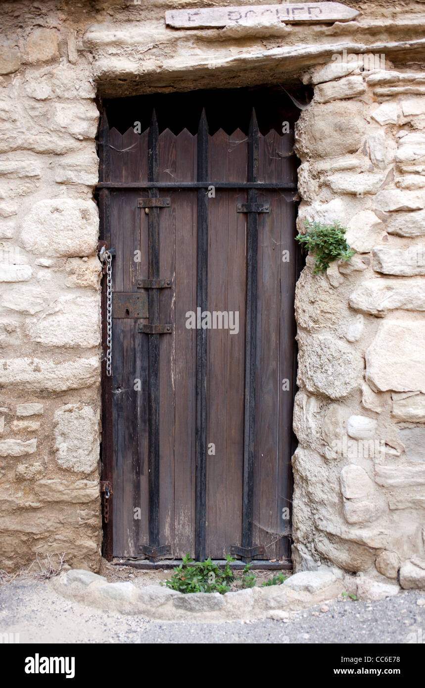 Un vieux brown interdit porte dans un mur de pierre à Saignon, France Banque D'Images