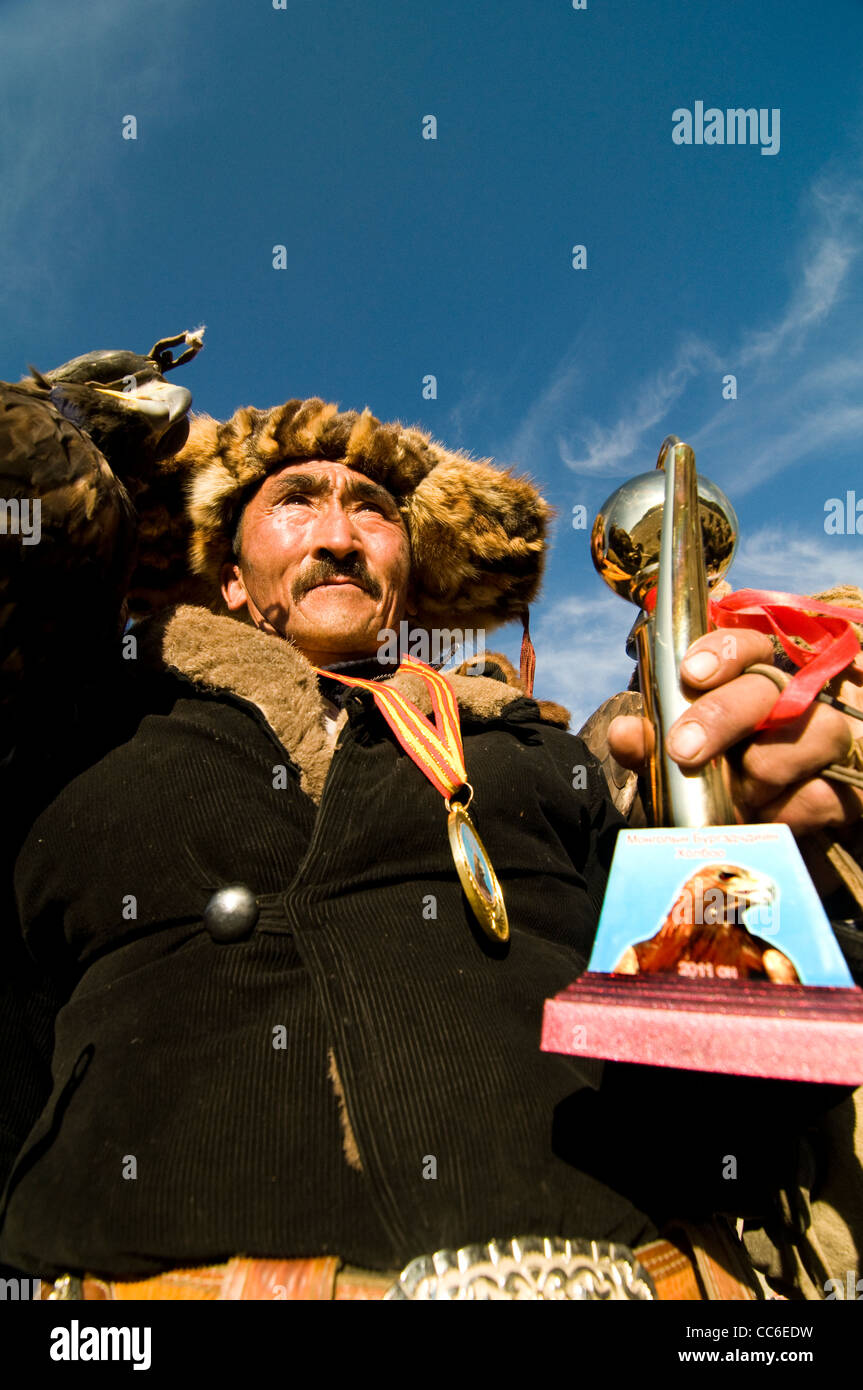 Le gagnant du concours de chasse aigle Kazakh à Bayan Olgii tenant son trophée. Banque D'Images
