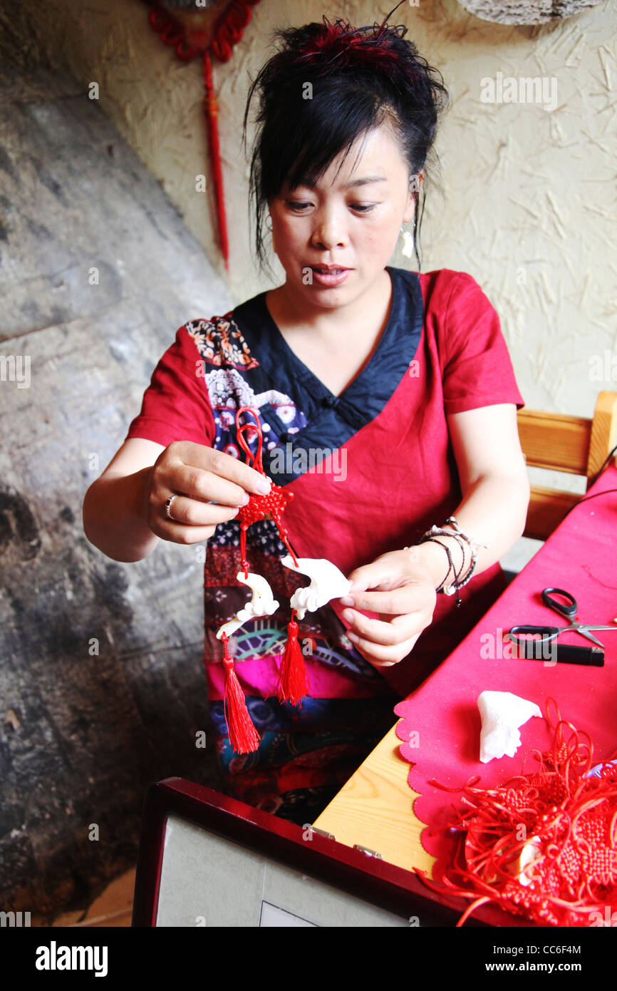 Femme Hezhe montrant une arête d'ornements, de l'Anhui en Chine , Banque D'Images