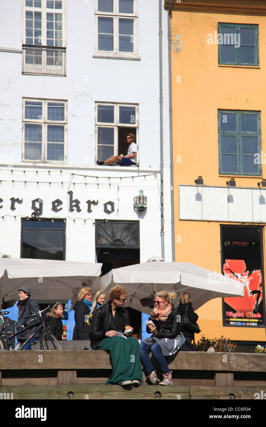 Les gens à discuter les uns avec les autres tout en restant assis sur la banque, Quartier Canal Sluseholmen, Copenhague, Danemark Banque D'Images