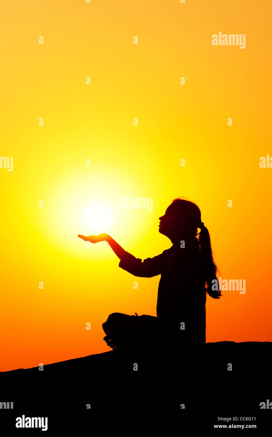 Indian girl holding le soleil. Silhouette. L'Inde Banque D'Images