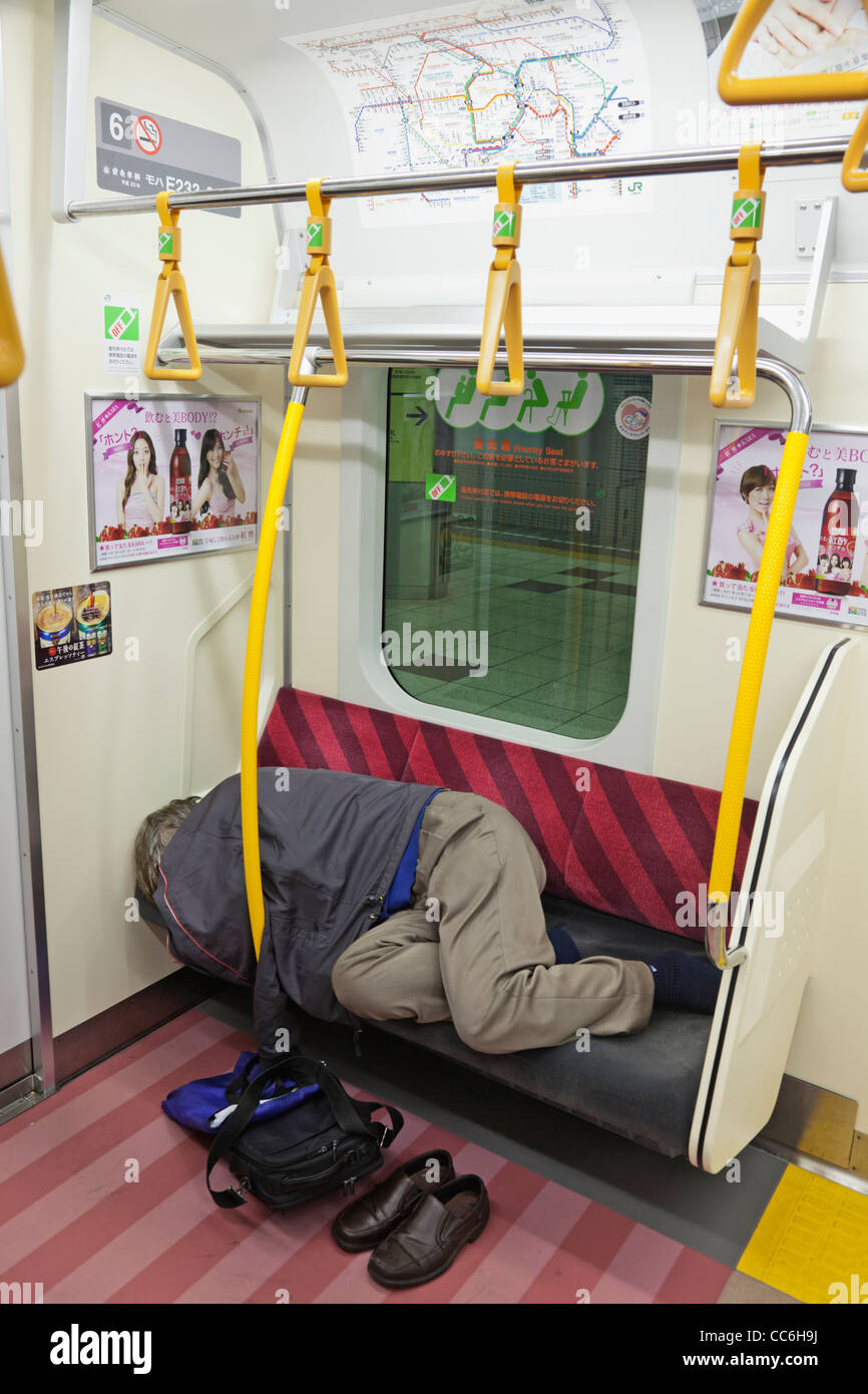 Japon, Tokyo, Man Sleeping on Subway train Banque D'Images