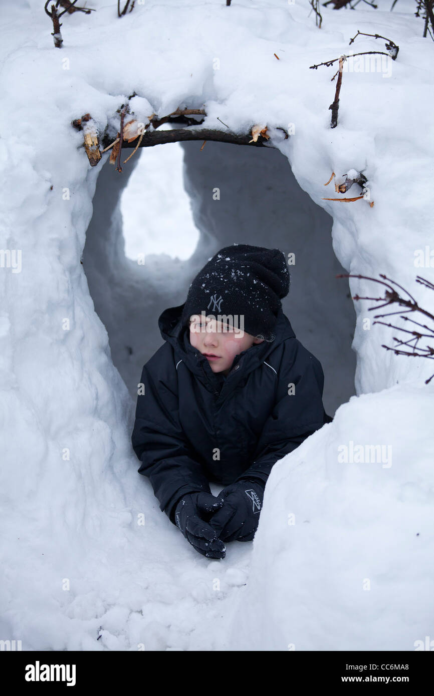 Jeune garçon jouant dans un igloo à Kahler Asten près de Winterberg, Sauerland, Rhénanie-du-, Allemagne Banque D'Images