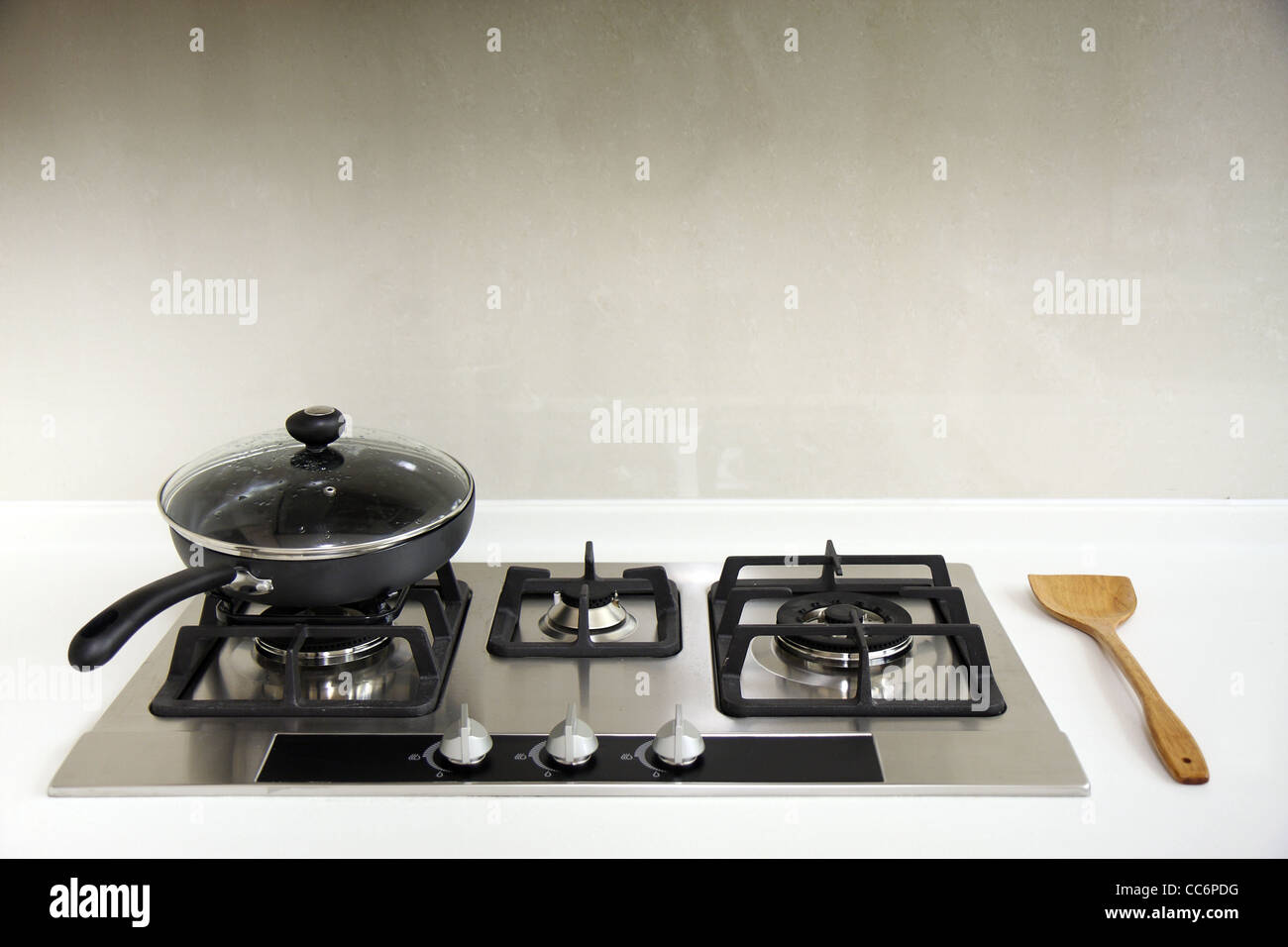 Une cuisine équipée d''une plaque de cuisson avec une casserole et une louche en bois. Banque D'Images