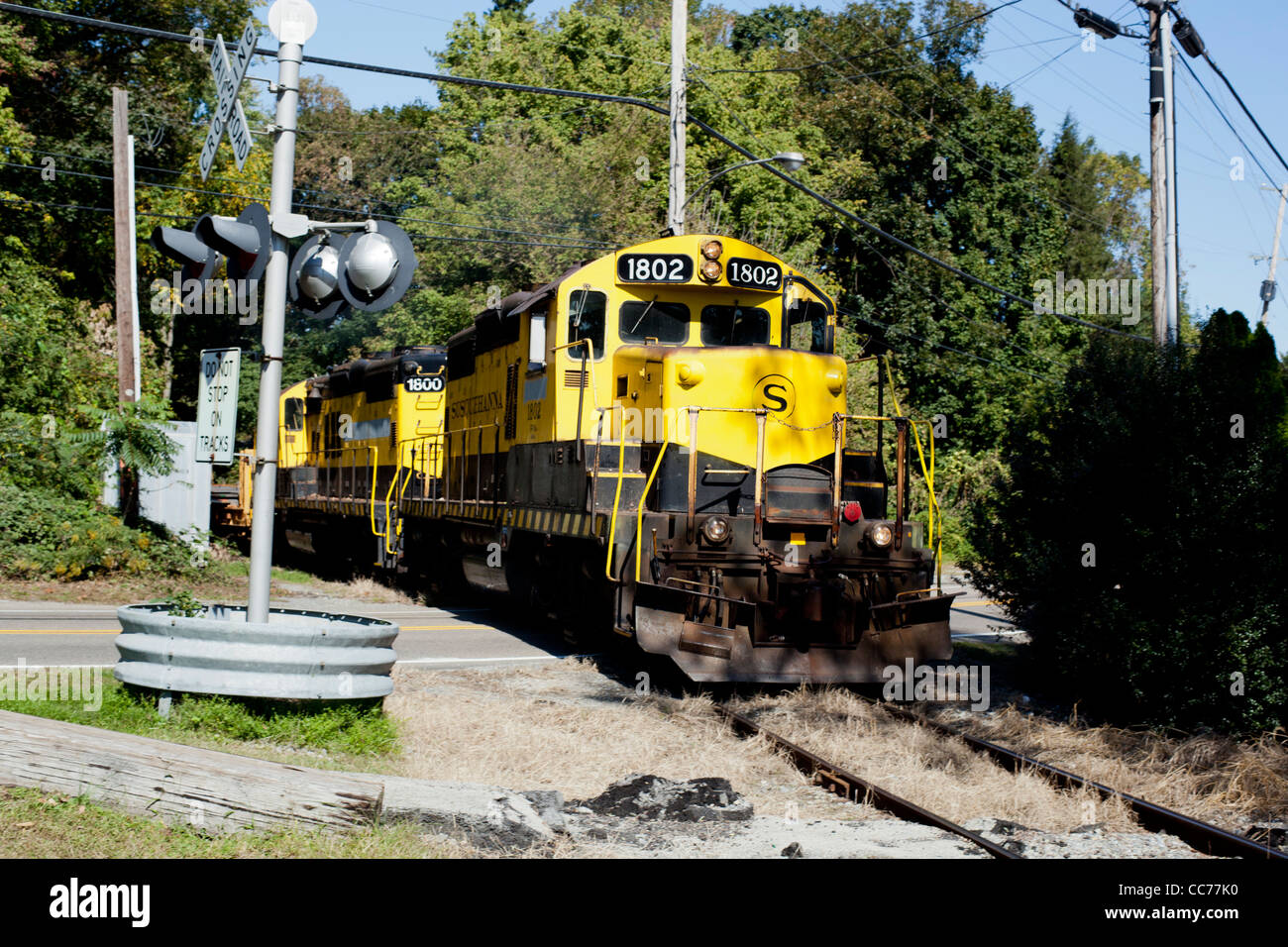 Locomotive Train Jaune moteur cheval de fer comme il traverse street Banque D'Images