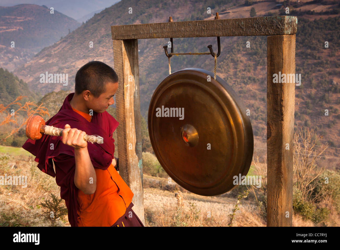 L'Inde, de l'Arunachal Pradesh, Dirang Gompa bouddhiste nouvellement construit, jeune moine gong en grève momks à appeler à la prière Banque D'Images