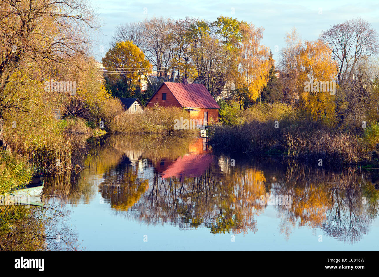 Maisons de village près de la rivière. Les arbres d'automne bateaux de l'eau. Banque D'Images