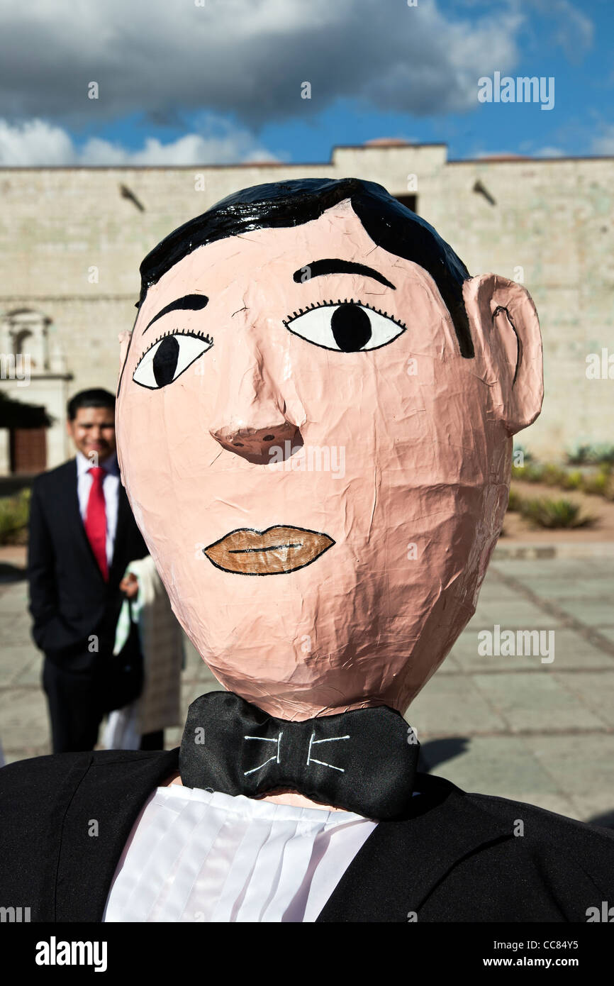 Tête de papier mâché d'une marionnette géante groom figure sur la plaza à l'extérieur de l'église Santo Domingo après une procession de mariage Oaxaca Banque D'Images