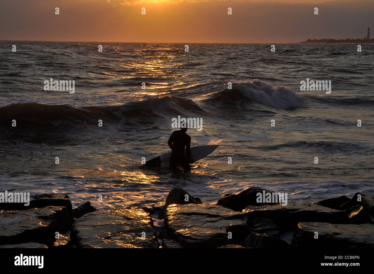 Surfer silhouetted against coucher de soleil à Cape May dans le New Jersey Banque D'Images