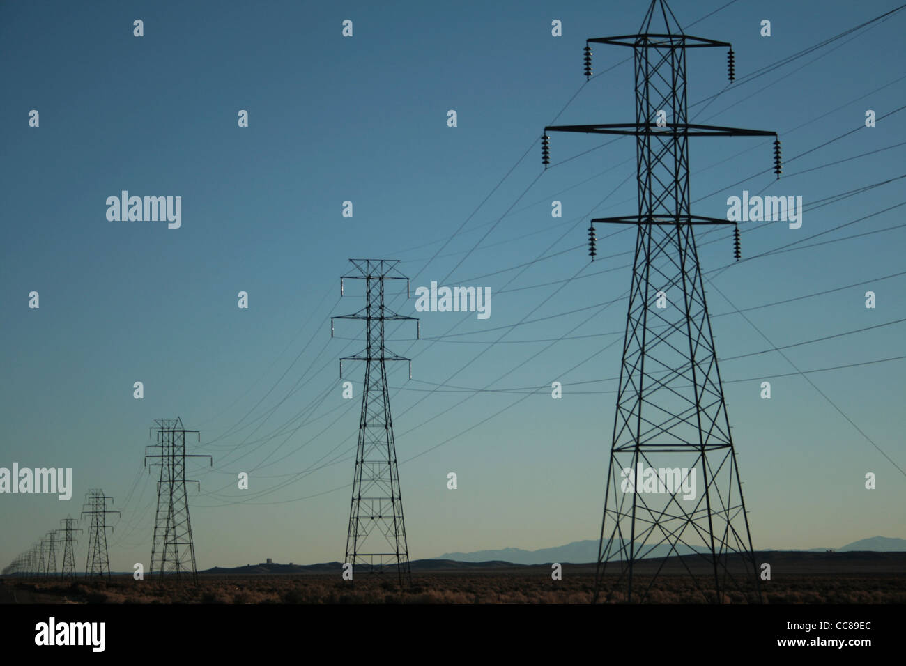 Rangées de lignes de transmission d'énergie électrique passer à la distance près de Sunset Banque D'Images